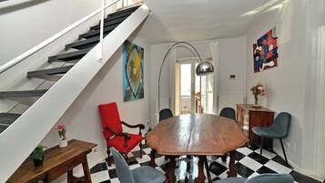 A dining area with a checkered floor, a wooden table, and chairs.