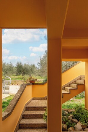 A staircase leading to an outdoor area with a view of trees and a clear sky. - Lake View Apt. w/ Wi-Fi & Parking in San Feliciano (San Feliciano)