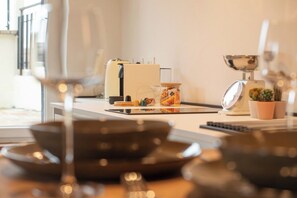 A kitchen with a coffee maker, a jar of snacks, a scale, and a potted plant. - Romantic Suite w/ Private Terrace Near Assisi (Rivotorto)