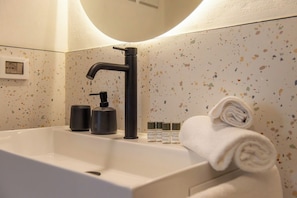 A bathroom with a white sink, black faucet, and a towel. - Romantic Suite w/ Private Terrace Near Assisi (Rivotorto)