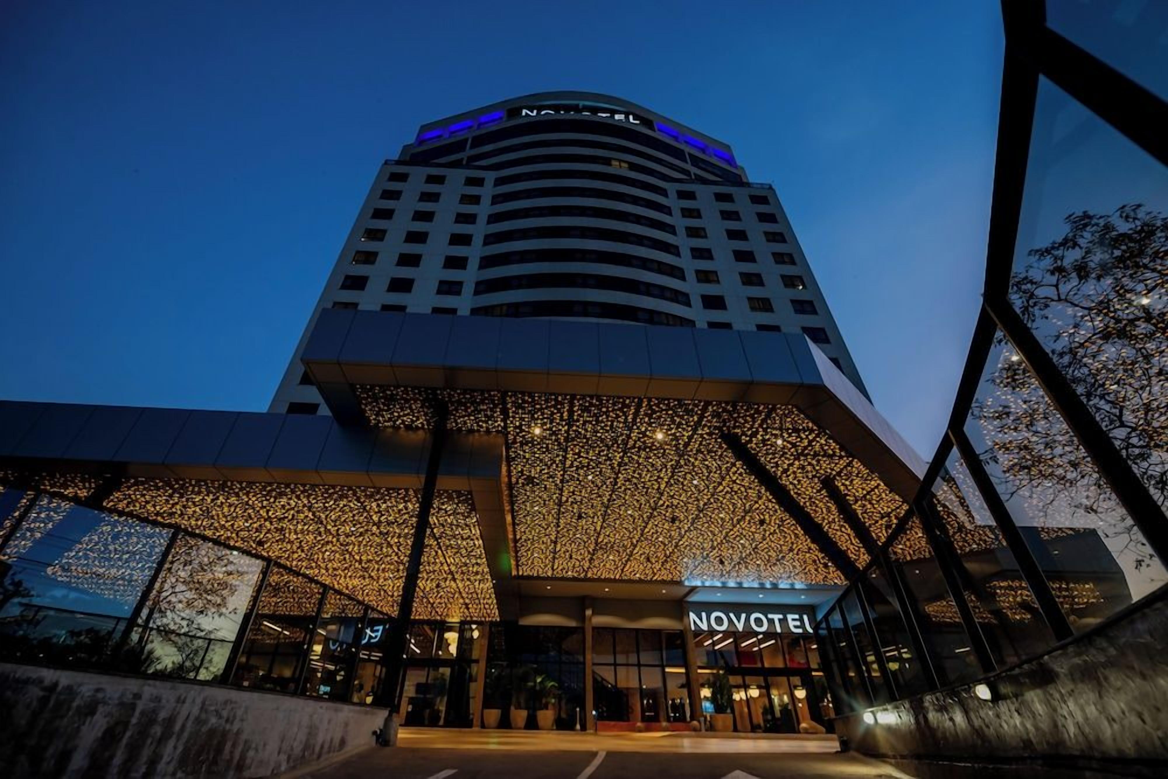 A hotel with a modern design, featuring a prominent entrance and a large, illuminated facade.