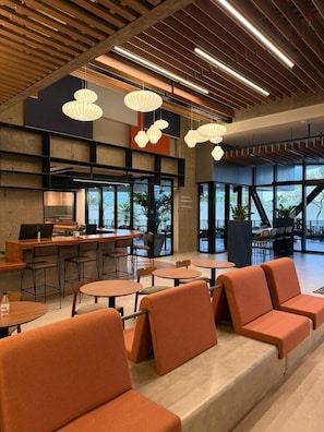 A modern interior with seating areas, a bar, and large windows. - Novotel Uberlandia (Uberlandia)