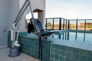 Un área junto a la piscina con una silla, un aspirador y una grúa.