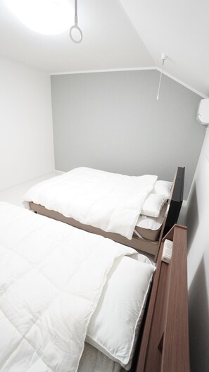 Ein Schlafzimmer mit einem Bett, einem Nachttisch, einer Wandlampe und einer Deckenleuchte.