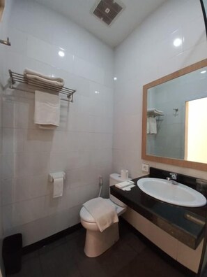 A small, modern bathroom with a toilet, sink, and mirror. - Batam Harbour Hotel 2 (Batam)