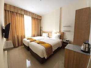 A hotel room with a bed, bedside tables, a desk, and a television. - Batam Harbour Hotel 2 (Batam)