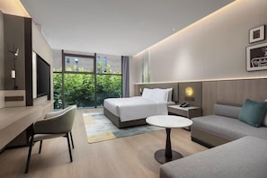 Une chambre d’hôtel moderne équipée d’un lit, d’un canapé, d’un bureau et d’une télévision.