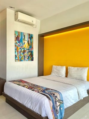 A hotel room with a large bed, a colorful artwork on the wall, and a modern headboard. - Picasso Style (Jakarta)