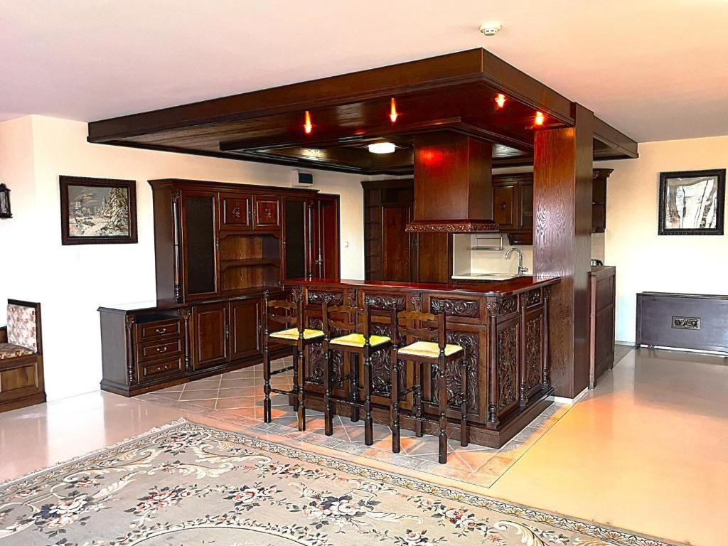 Une cuisine dotée d’un îlot central, de tabourets de bar et d’un tapis décoratif.