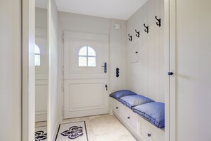 A narrow hallway with a white door, a small window, and a bench with a blue cushion. - The “large artists’ community,” with excellent access to the West Beach in Wenningstedt (Wenningstedt-Braderup (Sylt))