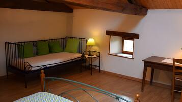 Quarto pequeno e aconchegante com cama, escrivaninha e janela.