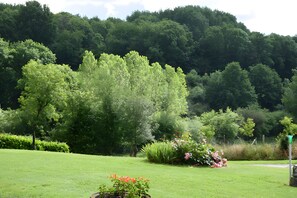 Een weelderig groen landschap met verschillende bomen en een verzorgd gazon.