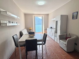 Un pequeño comedor con una mesa, sillas y vistas al exterior.
