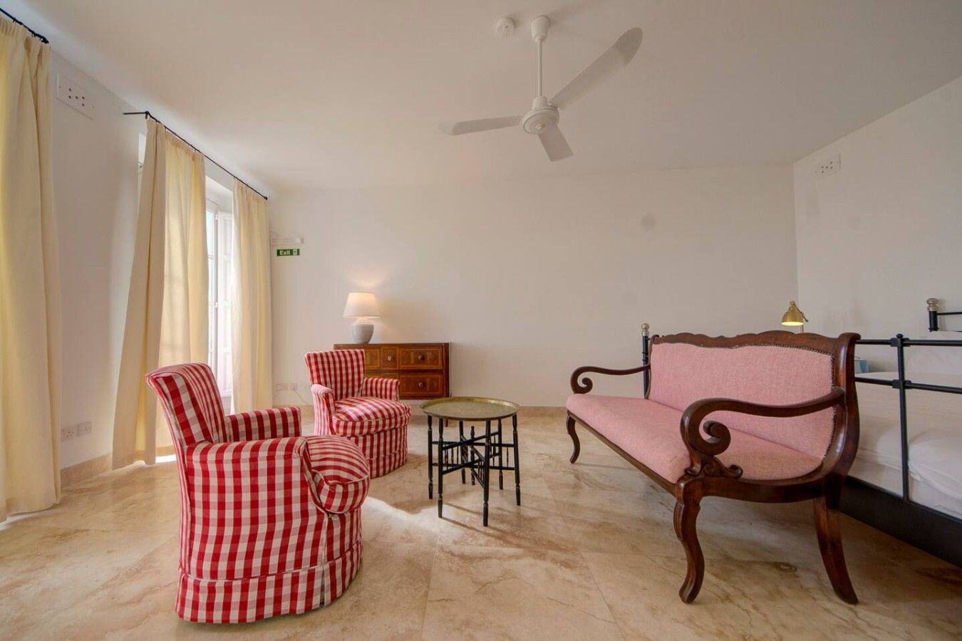 A room with a wooden bench, a small round table, and checkered chairs.