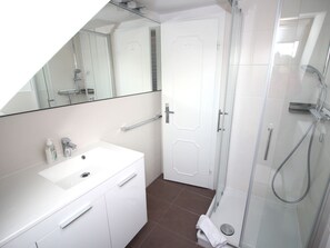 A modern bathroom with a white sink, mirror, and shower. - Holiday Apartment in Sylt With 2 Bedrooms (Sylt)