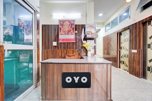A reception desk with a sign reading 'OYO' in a hotel lobby.