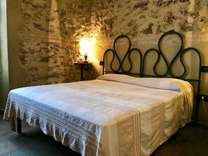 A single bed with a white bedspread and a headboard with a unique curved design. - Holiday Apartment With 2 Bedrooms (Massa Marittima)