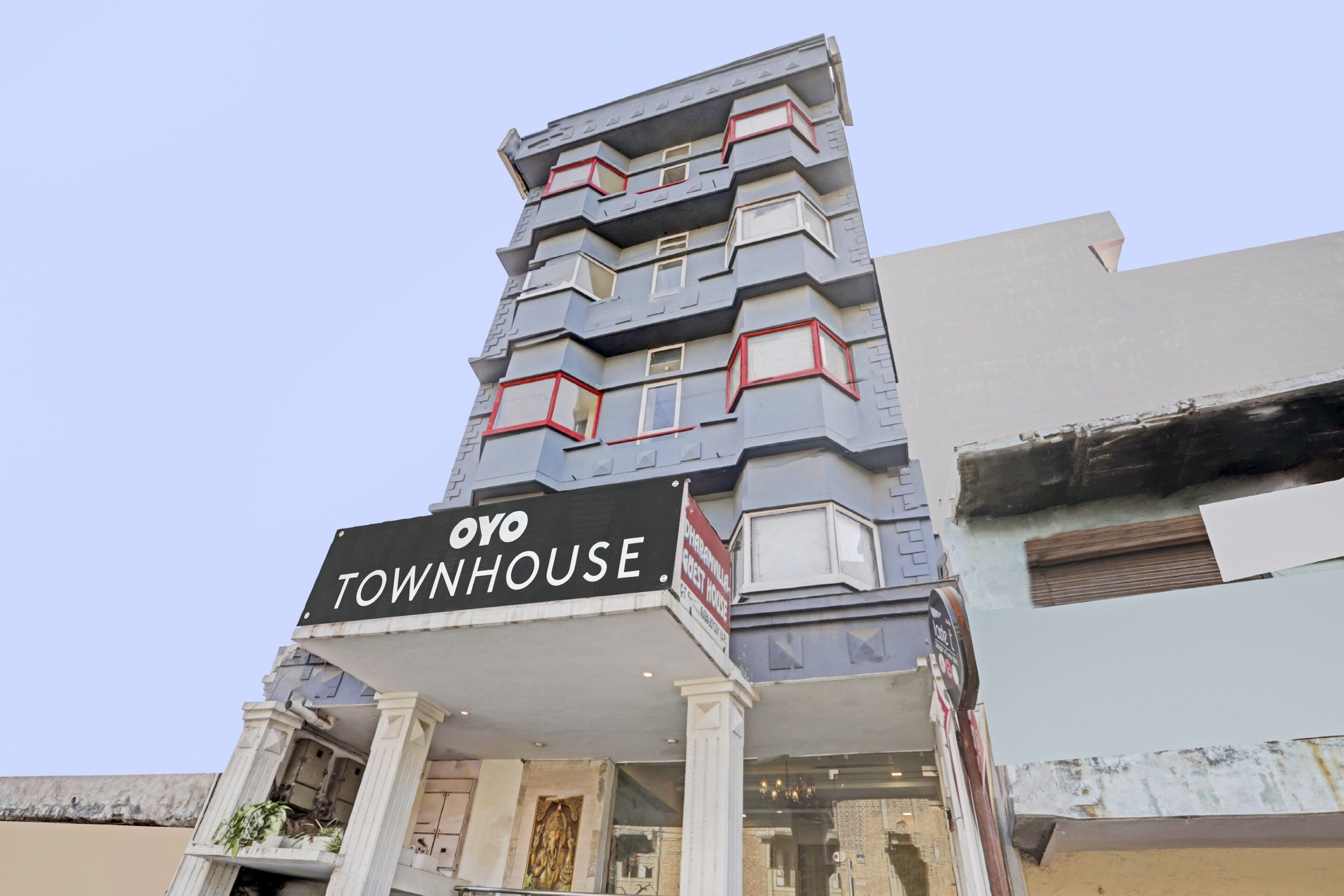 A multi-story building with a sign reading 'OYO TOWNHOUSE.'