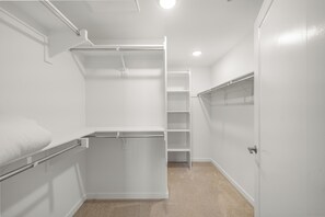 A walk-in closet with open shelving, a hanging rod, and a ladder for storage. - Chic Resort-Style 2BR - Pools, BBQ & Balcony (Lake Forest)