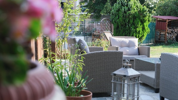 An outdoor seating area with wicker furniture and a cushioned chair.