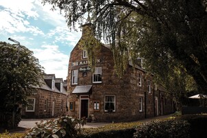Un edificio de piedra con un letrero que dice 'The Mash Tun' y 'Whisky Bar', indicando un pub.