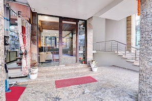 A hotel lobby with a marble floor, a staircase, and a glass door leading to the interior. - Townhouse OAK The Hotel Square Villa (Ghaziabad)