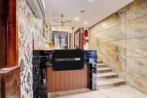 A hotel entrance with a sign reading 'TOWNHOUSE OAK,' a staircase, and a ceiling fan.