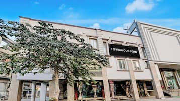 A building with a sign reading 'TOWNHOUSE OAK' and storefronts with glass fronts.