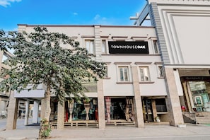 A townhouse with a storefront labeled 'TOWNHOUSEAK' and a tree in front. - Townhouse OAK The Hotel Square Villa (Ghaziabad)