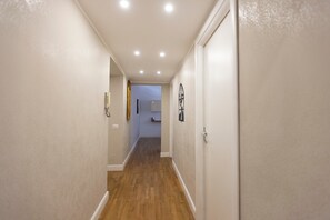 A narrow hallway with wooden flooring, white walls, and a door at the end. - Apartment 'Trastevere Amphora House' with Wi-Fi and Air Conditioning (Roma)