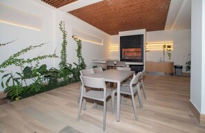 Eine moderne Küche mit Backofen und einer Essecke mit Holztisch und Stühlen.