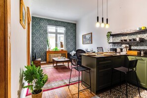 Una cocina compacta con comedor, ventana y una planta.