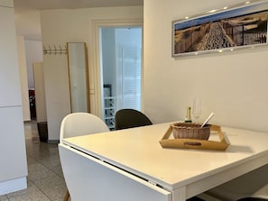 A dining area with a table, chairs, a bottle, and a glass. - at the South Grove 3 (Sylt)