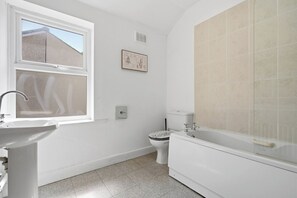 A bathroom with a window, a sink, a toilet, and a bathtub. - Beautiful 2 Bed House with Parking in Birmingham (West Midlands)