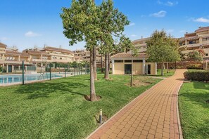 A residential area with a swimming pool, paved pathways, and a small building. - Apartment 'Baviera Golf Resort' with Shared Pool, Private Terrace and Wi-Fi (Caleta de Vélez)