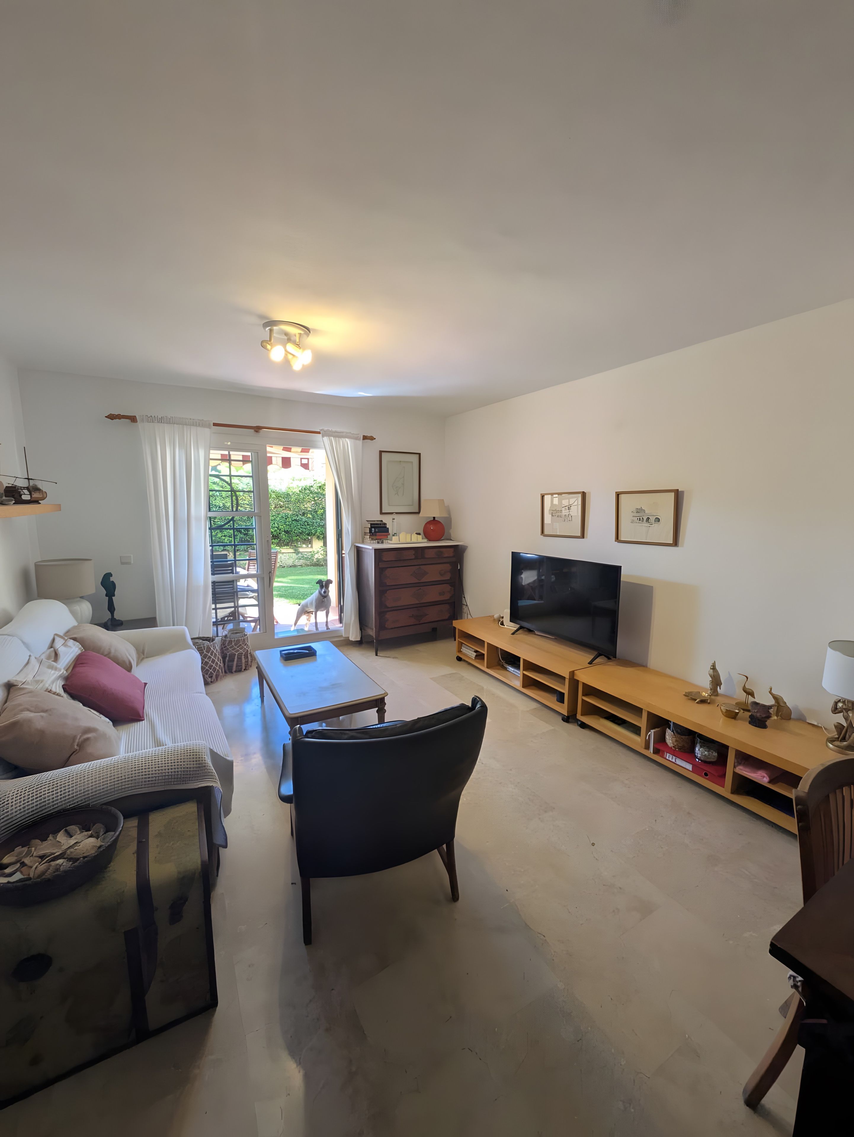 Ein Wohnzimmer mit einer Couch, einem Couchtisch, einem Fernseher und einer Holz-Unterhaltungseinrichtung.