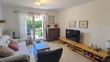 Ein Wohnzimmer mit einer Couch, einem Couchtisch, einem Fernseher und einer Holz-Unterhaltungseinrichtung.