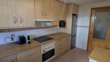 Eine Küche mit Holzausstattung, einer Mikrowelle, einem Toaster und einem Geschirrspüler.