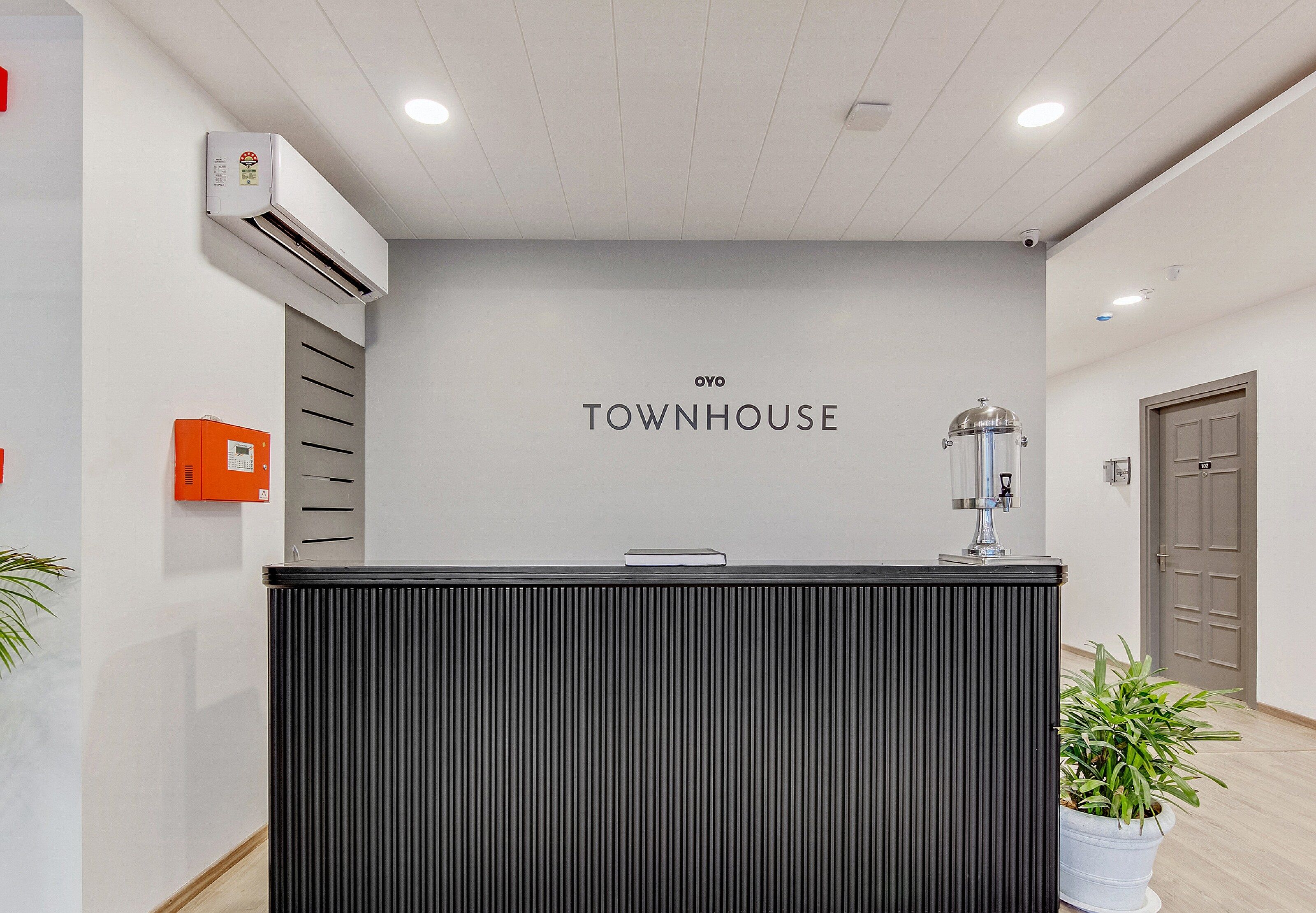 Un comptoir d’accueil avec une enseigne indiquant « OYO TOWNHOUSE ».