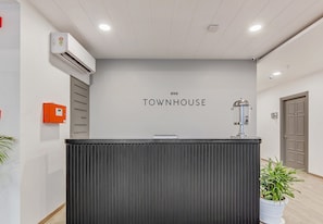 Una mesa de recepción con un cartel que dice 'OYO TOWNHOUSE'.