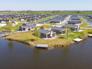 A residential area with modern houses arranged in rows alongside a water body. - Holiday Home in Kampen With Swimming Pool (Kampen)