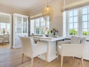 A modern kitchen with a central island, white cabinetry, and a hanging light fixture. - Holiday Apartment With 1 Bedroom (Kampen)
