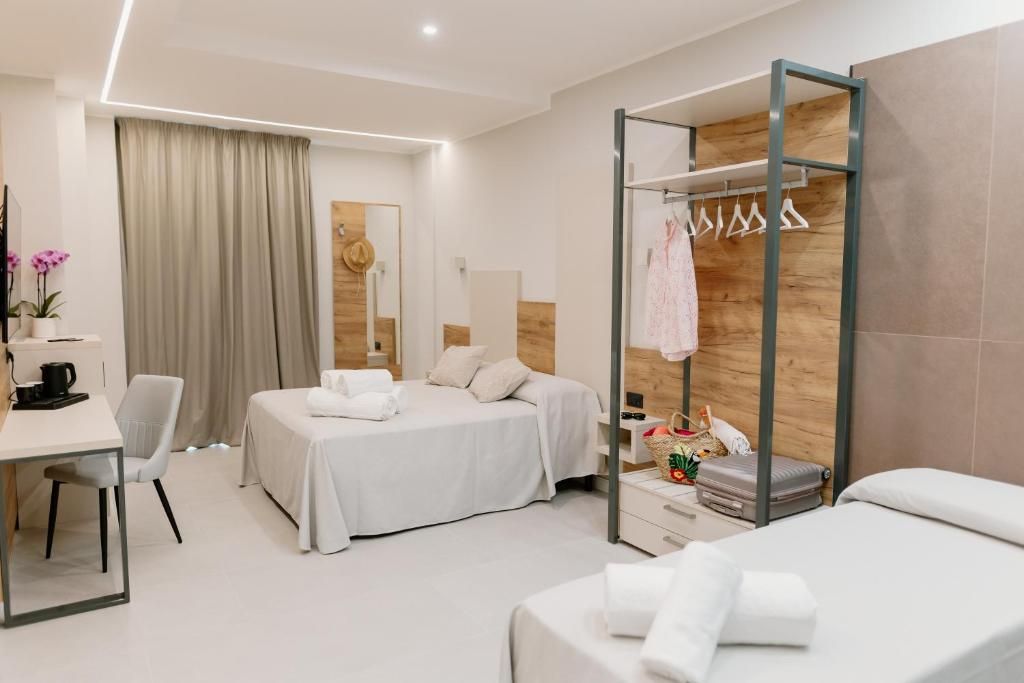 Habitación de hotel moderna con dos camas, un escritorio, una silla, un armario y un espejo.