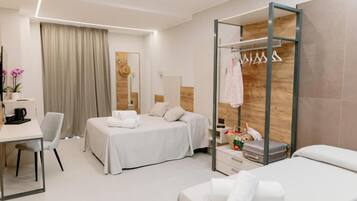 Habitación de hotel moderna con dos camas, un escritorio, una silla, un armario y un espejo.