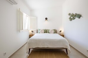 A bedroom with a bed, bedside lamps, a wall-mounted light, and a window with blinds. - Luxury Lagos Villa, with Seaview. Close to the Old Town and pristine beaches (Lagos)