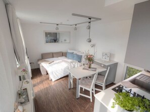 A compact bedroom with a bed, bedside table, and a desk with a chair. - Cabin in Renesse With Swimming Pool (Renesse)