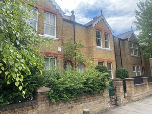 A two-story brick house with a traditional design, featuring a front garden and a visible mailbox. - Spacious 5-Bed Victorian Home with Garden near Richmond & London (Richmond)