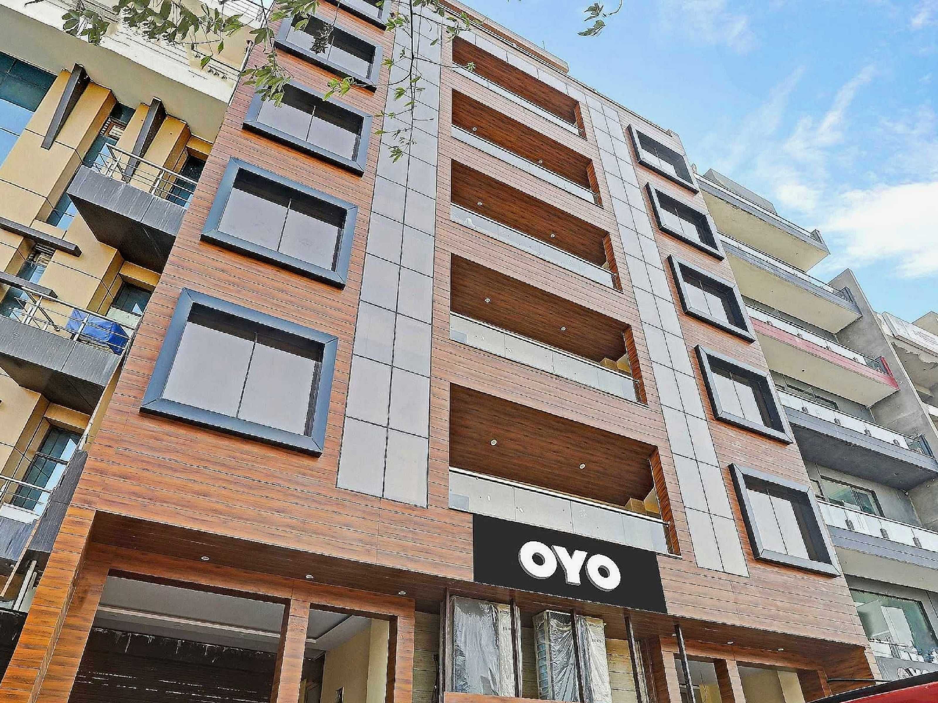 A multi-story building with a prominent 'OYO' sign on the ground floor, indicating a hotel or lodging establishment.