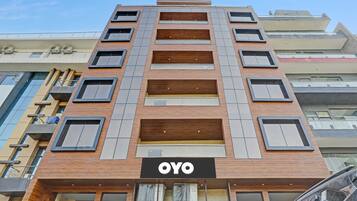 En flereetagers bygning med et tydeligt 'OYO'-skilt på facaden, med et moderne arkitektonisk design, der kombinerer træ og metal.