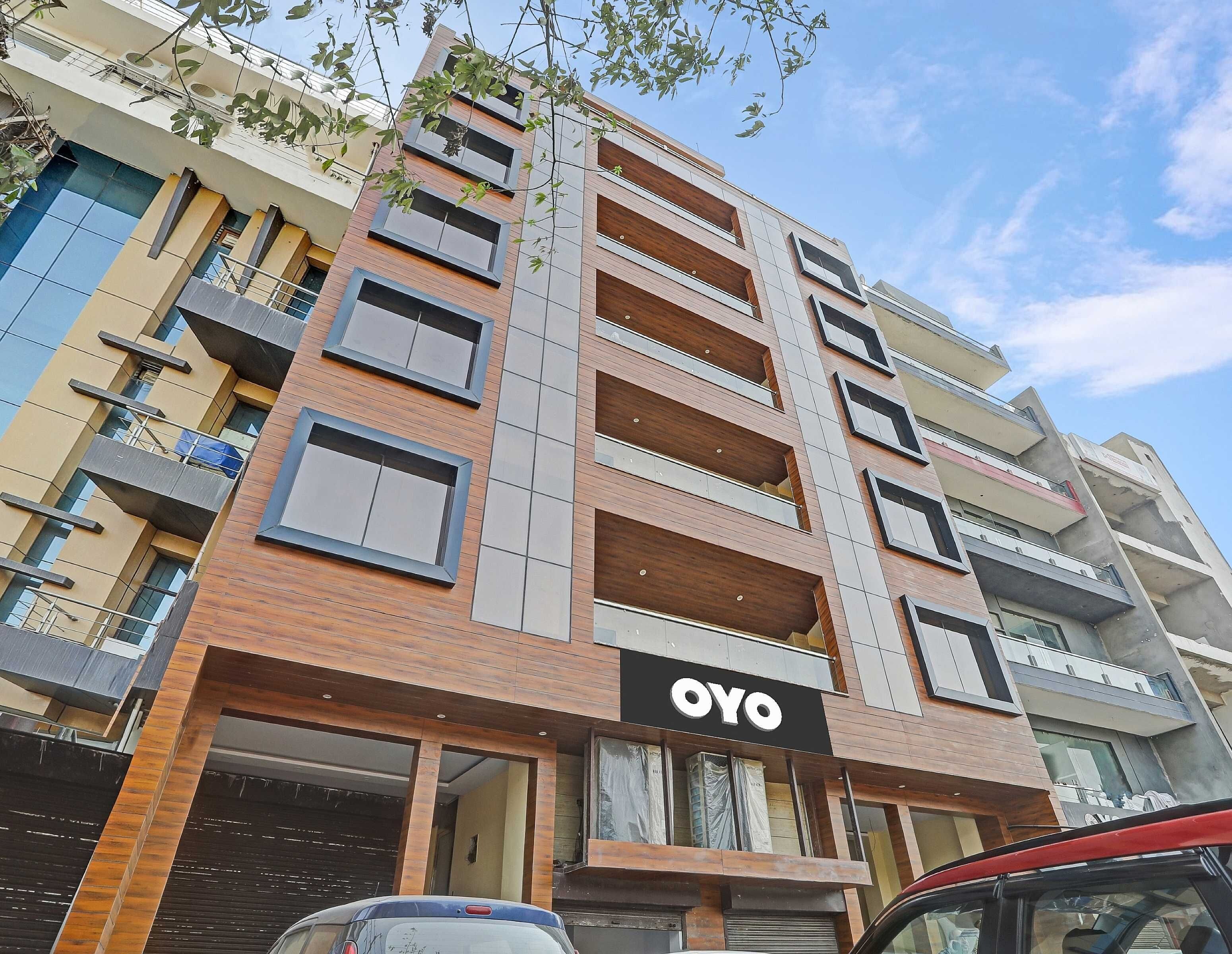 A multi-story building with a prominent 'OYO' sign, balconies, and a garage entrance.